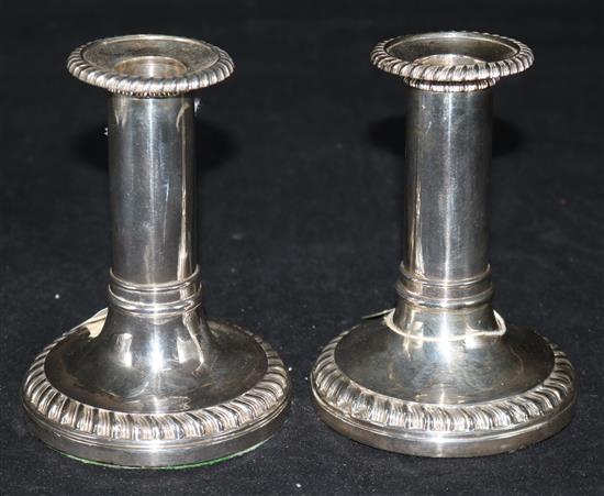 A pair of George III silver dwarf candlesticks, with plain columns and gadroon edges (weighted), Sheffield 1817, John & Thomas Settle